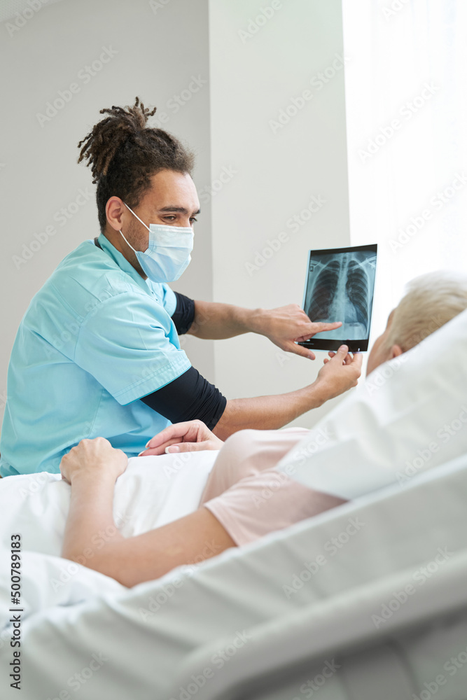 Yound medic demonstrating x-ray to old patient Yound medic demonstrating x-ray to old patient
