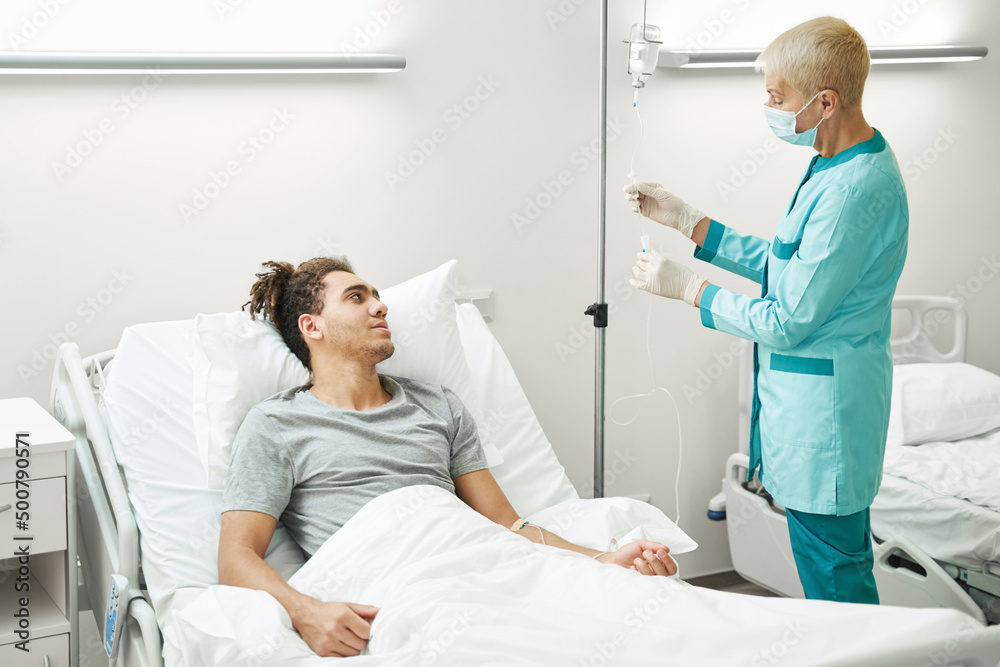 Obraz premium Medical professional using drip chamber of intravenous line