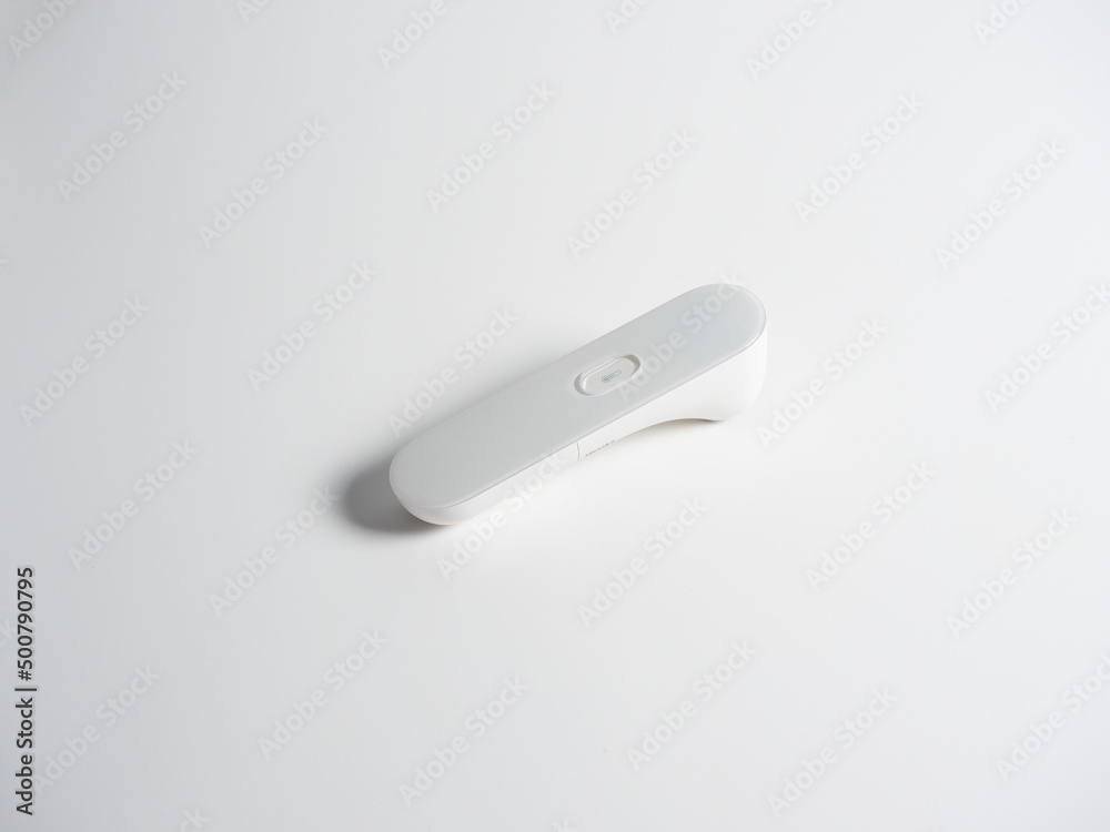 Close-up of an electronic thermometer gun for diagnosing body temperature at a distance. Isolated white background. Medical devices Close-up of an electronic thermometer gun for diagnosing body temperature at a distance. Isolated white background. Medical devices