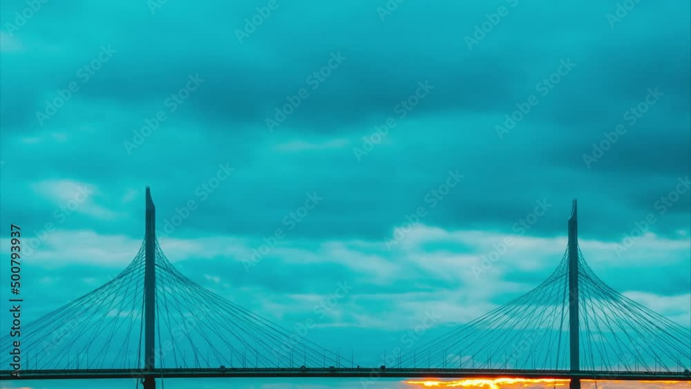Cable-stayed bridge against the backdrop of sunset and cloudy sky in st. petersburg, timelapse. The rays of the sun break through the clouds beautifully. Cable-stayed bridge against the backdrop of sunset and cloudy sky in st. petersburg, timelapse. The rays of the sun break through the clouds beautifully.