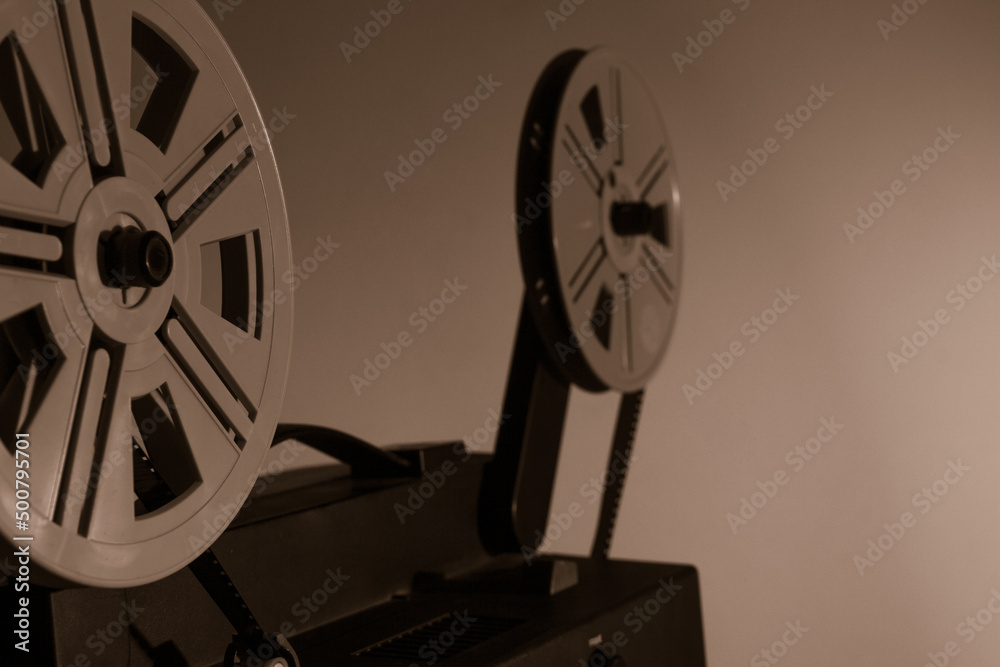 Obraz premium Old vintage 8mm projector with film reels and film frames. Copy space. Selective focus.