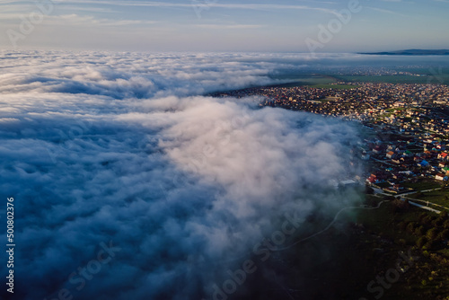 Aerial view with clouds and mountains. Foggy spring weather