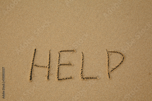 Help - handwritten on the soft beach sand.