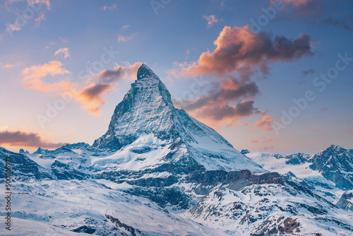 Idyllic view of snowcapped matterhorn mountain peak. Famous snow covered landscape against sky during sunset. Beautiful snowy valley in alps during winter.