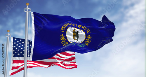 The Kentucky state flag waving along with the national flag of the United States of America photo