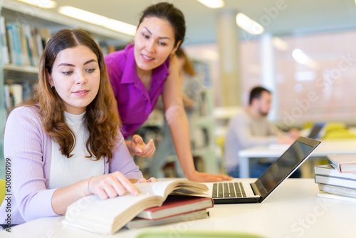 Portrait of cheerful female friends together in public library