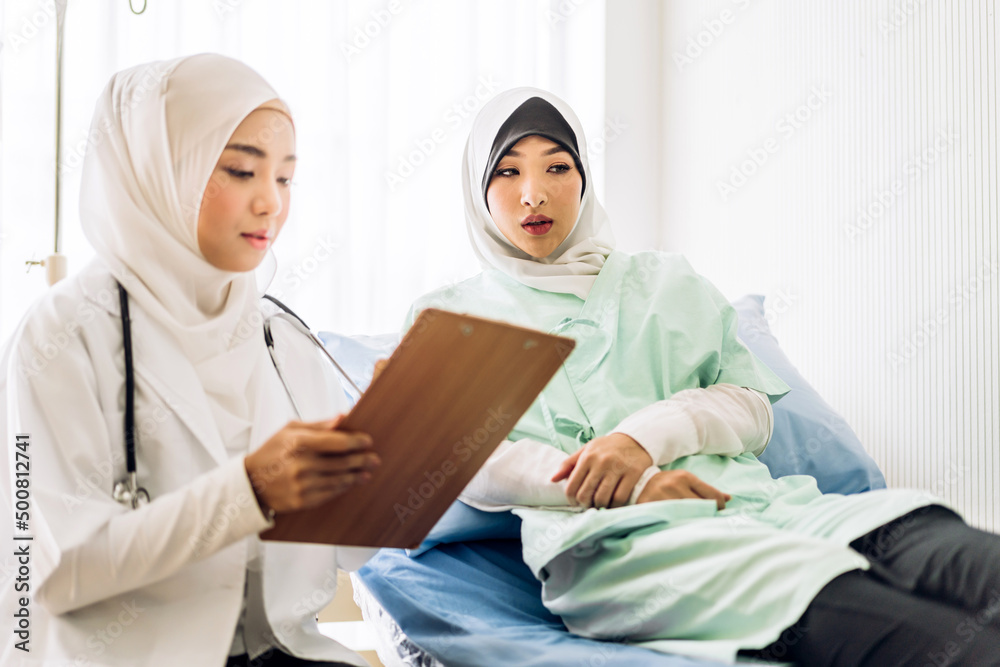 Muslim asian woman doctor service help support discussing and consulting talk to muslim woman patient at meeting health medical care express trust concept in hospital.healthcare and medicine Muslim asian woman doctor service help support discussing and consulting talk to muslim woman patient at meeting health medical care express trust concept in hospital.healthcare and medicine