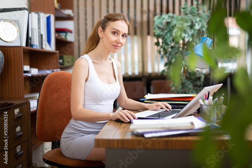 фотографія Portrait of a young sexy woman business manager working at a computer in the off