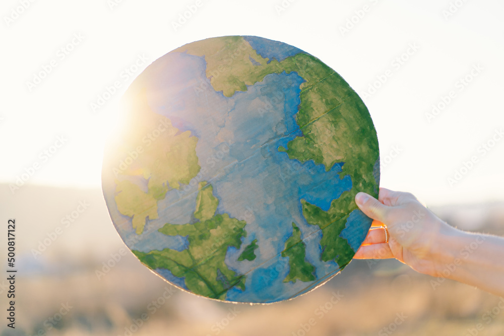 Protection and love of earth. Woman holding planet in hands against green spring background. Earth day concept. Environmental Conservation Protection and love of earth. Woman holding planet in hands against green spring background. Earth day concept. Environmental Conservation