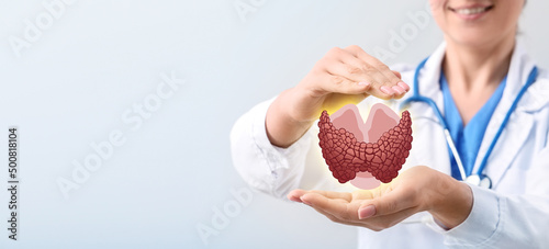 Female endocrinologist with digital projection of thyroid gland on light background, closeup photo