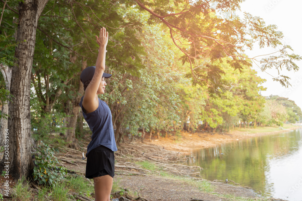 woman jogger stretching near the lake in the morning.