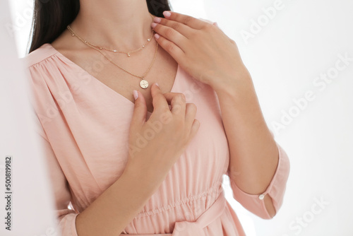 Young woman wearing beautiful necklace with pendant