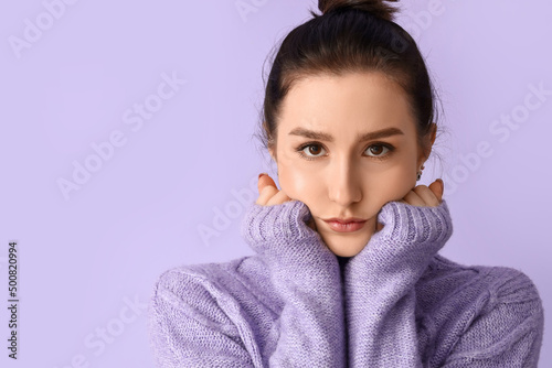Worried young woman on lila...