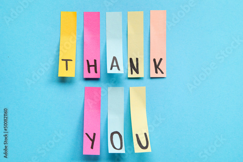 Sticky papers with text THANK YOU on blue background