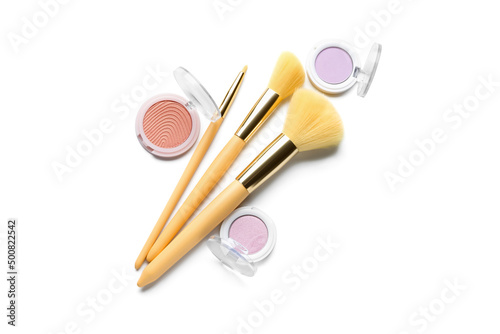 Eyeshadows and makeup brushes isolated on white, top view