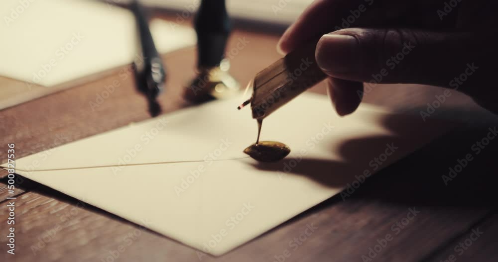 The caucasian hand carries the wax to the letter and then presses the wax seal into the hot wax to seal the letter. Close up shot - copy space