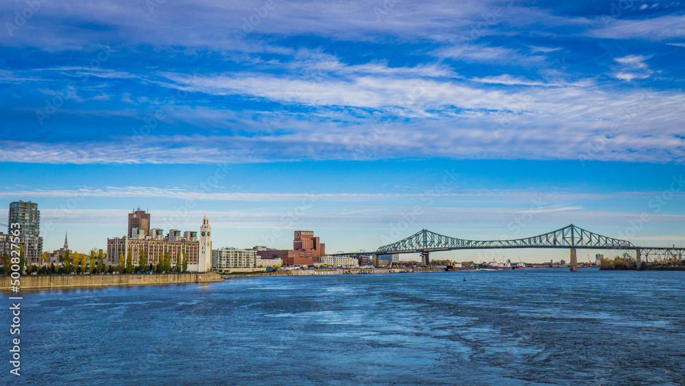 View on the St Lawrence river, Jacques Cartier Bridge, Molson factory and Montreal Old Port clock tower from the Jean Drapeau Park