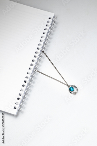 Wallpaper Mural Silver chain necklaces with blue diamond pendant on white office desk Torontodigital.ca