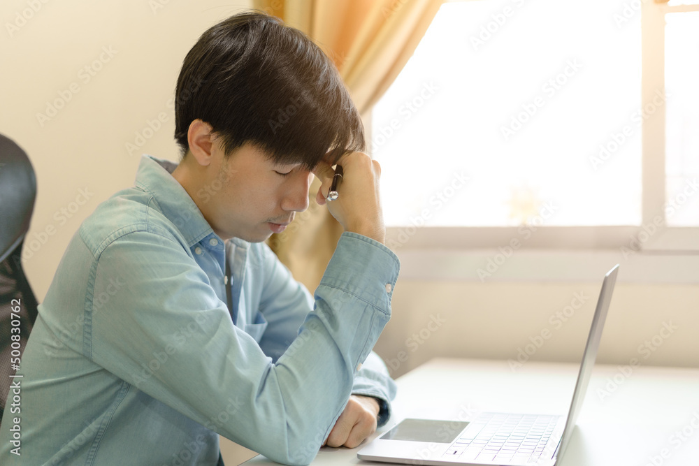 Stressed young businessman, trader or investor touch head, disappointed when bad investment or economic crisis, losing money from investing, trading stock, Cryptocurrency as Bitcoin on laptop at home. Stressed young businessman, trader or investor touch head, disappointed when bad investment or economic crisis, losing money from investing, trading stock, Cryptocurrency as Bitcoin on laptop at home.