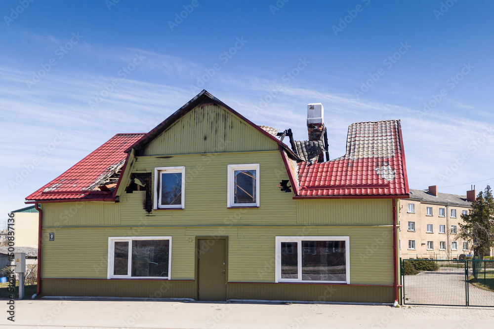 Abandoned, burnt house in sunny spring day.