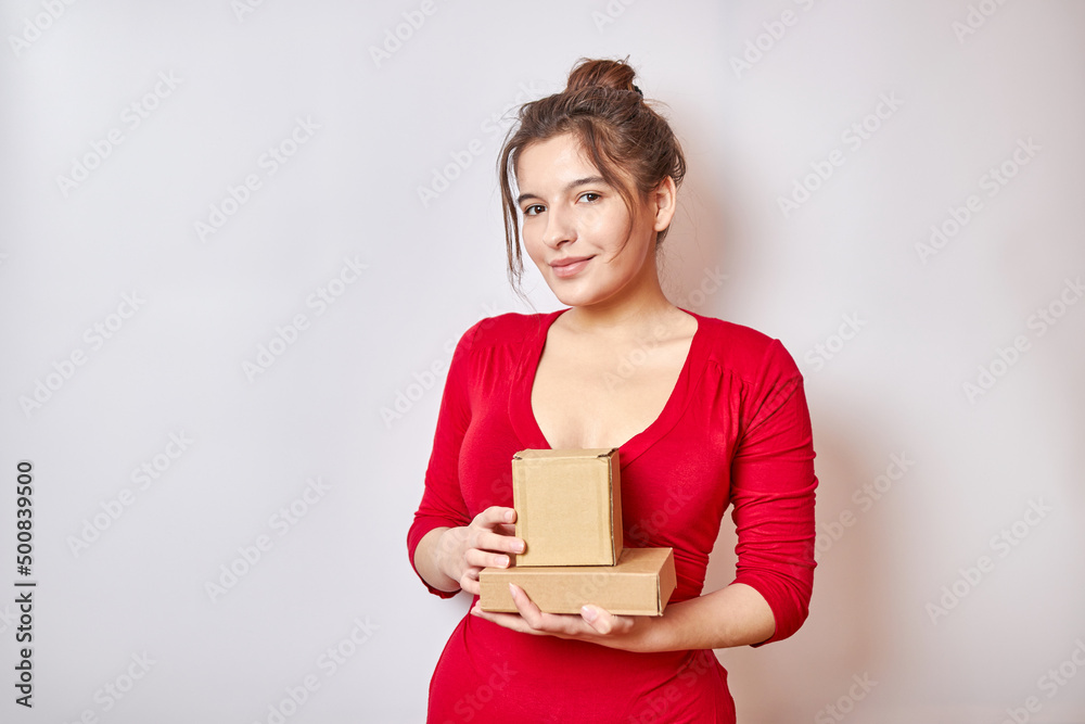 Beautiful girl dressed in a red dress holding a cardboard box. Beautiful girl dressed in a red dress holding a cardboard box.