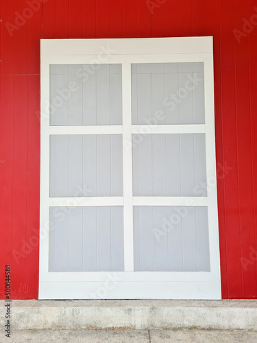 White large window frames and red walls.