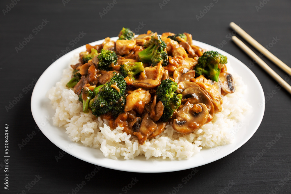 Homemade Chicken Veggie Stir Fry with White Rice on a black background, low angle view. Close-up. Homemade Chicken Veggie Stir Fry with White Rice on a black background, low angle view. Close-up.
