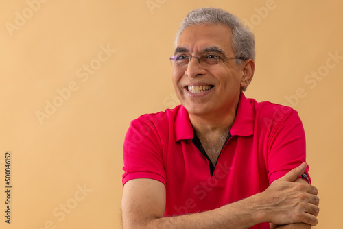 Close-up portrait of cheerful senior man looking elsewhere with smile photo