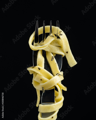 Some spaghetti with spices rolled up on a fork