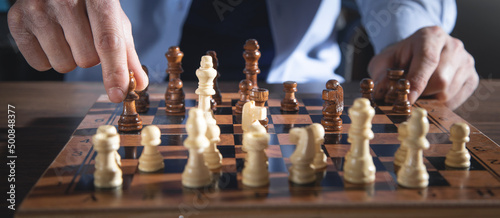 Fotografiet Caucasian man playing chess board game.