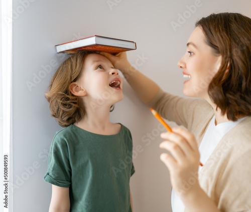 Kid and mother are measuring the growth
