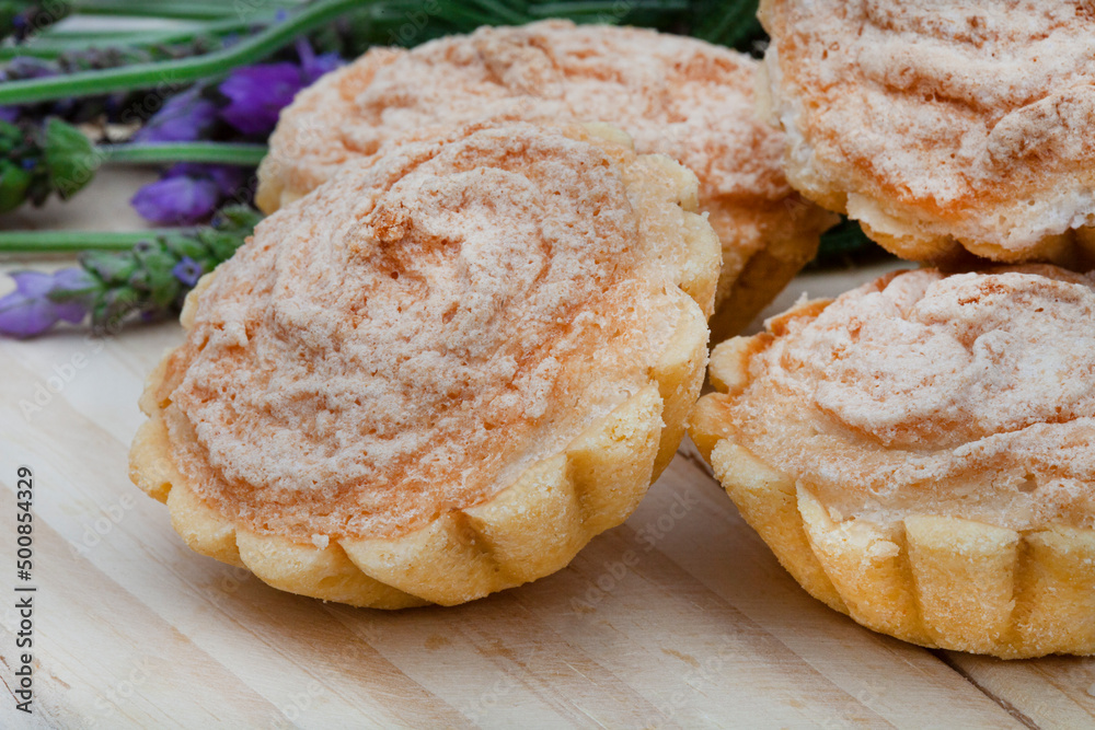 Traditional South African Hertzog koekies or tiny coconut tarts stuffed with apricot jam