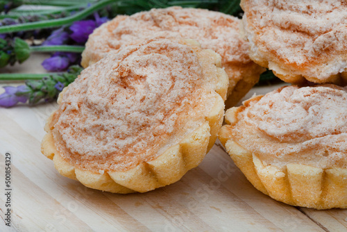 Traditional South African Hertzog koekies or tiny coconut tarts stuffed with apricot jam