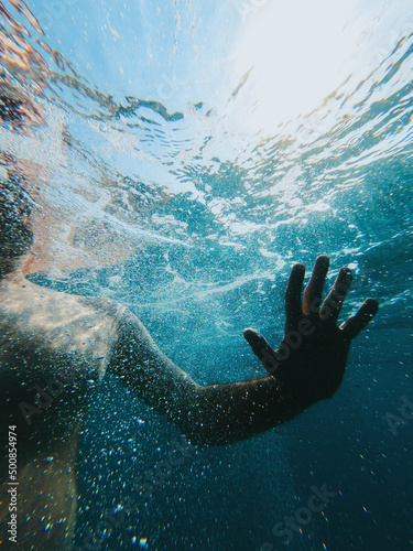 Underwater shot of male person swimming in sea water