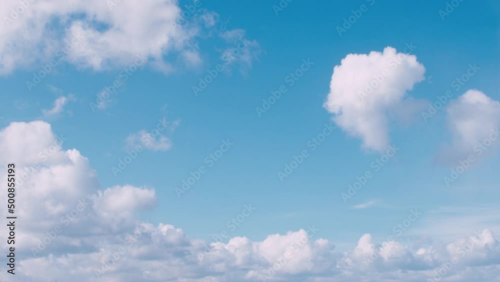 Time lapse of clouds and bright blue sky. Fast timelapse white and dark clouds moving towards the camera from background to foreground sideaways.