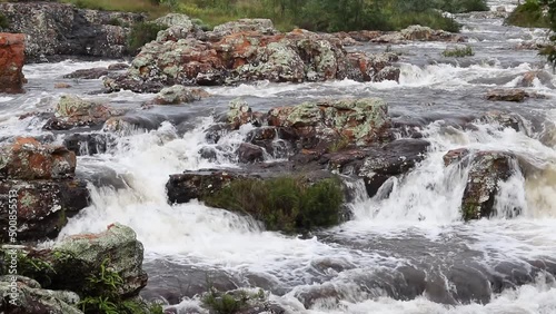 Static shot of white water forming while flowing over rocks. Filmed with a Canon 200D on a Tripod. photo