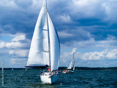 Sailboat sailing on a lake in a windy sunny summer day