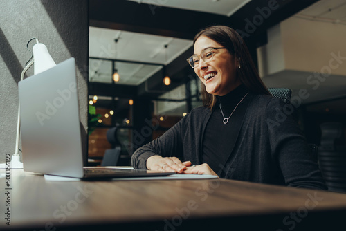 Smiling businesswoman attending an online meeting in a coworking office photo