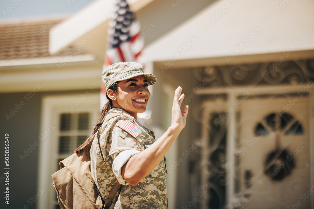 Happy servicewoman waving her hand on her homecoming Happy servicewoman waving her hand on her homecoming