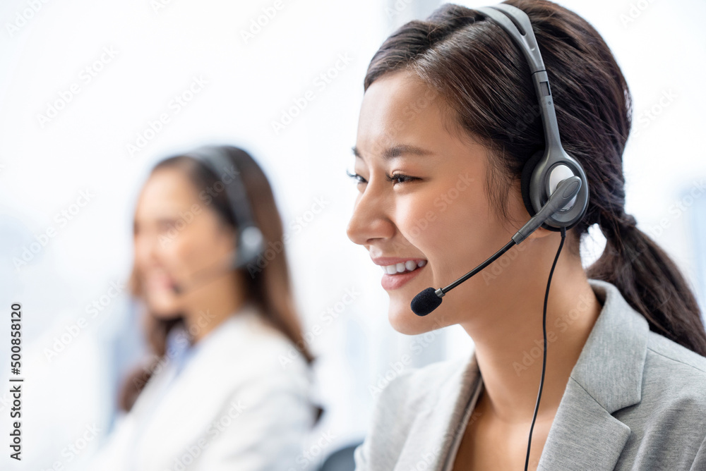 Cheerful Asian consultant in call center Cheerful Asian consultant in call center