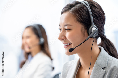 Cheerful Asian consultant in call center