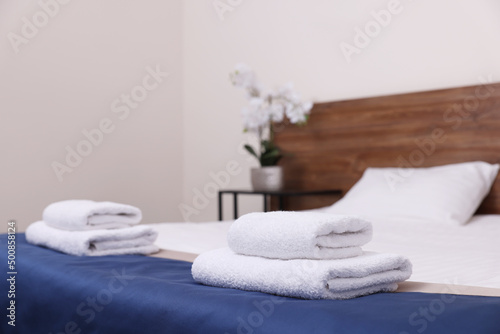 Clean folded towels on bed in hotel room © New Africa