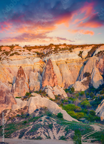 Beautiful summer view of Red Rose valley. Stunning sunrise in limestone canyon, Cavusin village location, Turkey, Asia. Beauty of nature concept background..