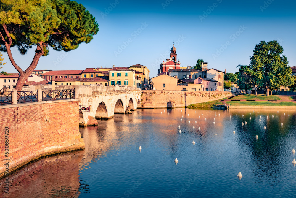 Beautiful morning view of Tiberiao bridge and Marecchia river. Attractive summer cityscape of Rimini town, Italy, Europe. Traveling concept background.