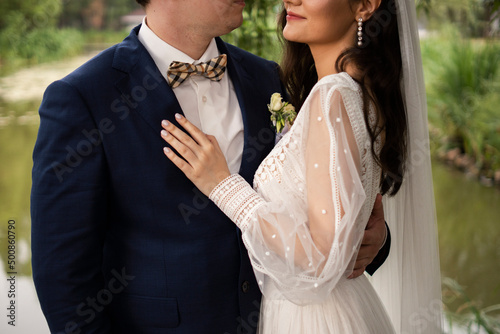 Smiling bride embracing groom standing with arm around