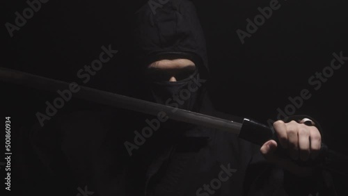 Medieval warrior assassin ninja with sword in aggressive pose in smoke