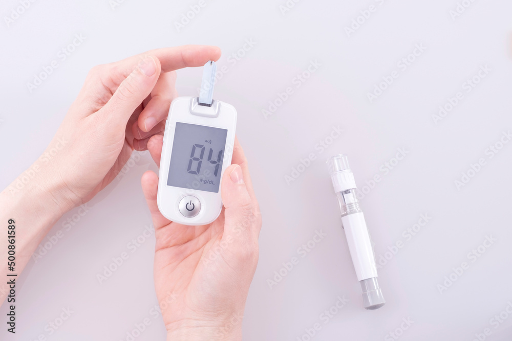 Human using a glucometer to measure and test blood glucose levels from ...