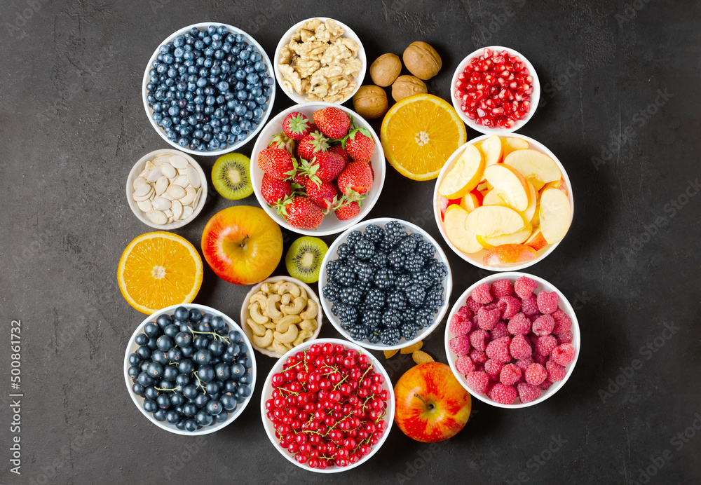 Berries, fruits and nuts on a black concrete background. Vegetarian food. Berries, fruits and nuts on a black concrete background. Vegetarian food.