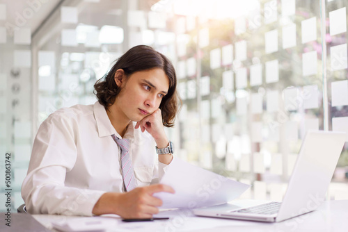 Business concept, Businessman reading financial report and analyze to make project on laptop