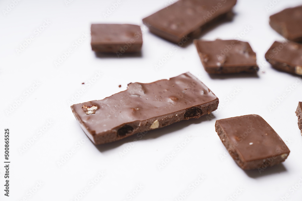milk chocolate with hazelnuts and raisins is isolated on a white background. cooking concept milk chocolate with hazelnuts and raisins is isolated on a white background. cooking concept